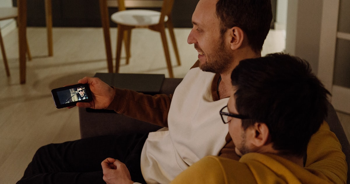 Deux hommes consultant une application de rencontre gay sur smartphone