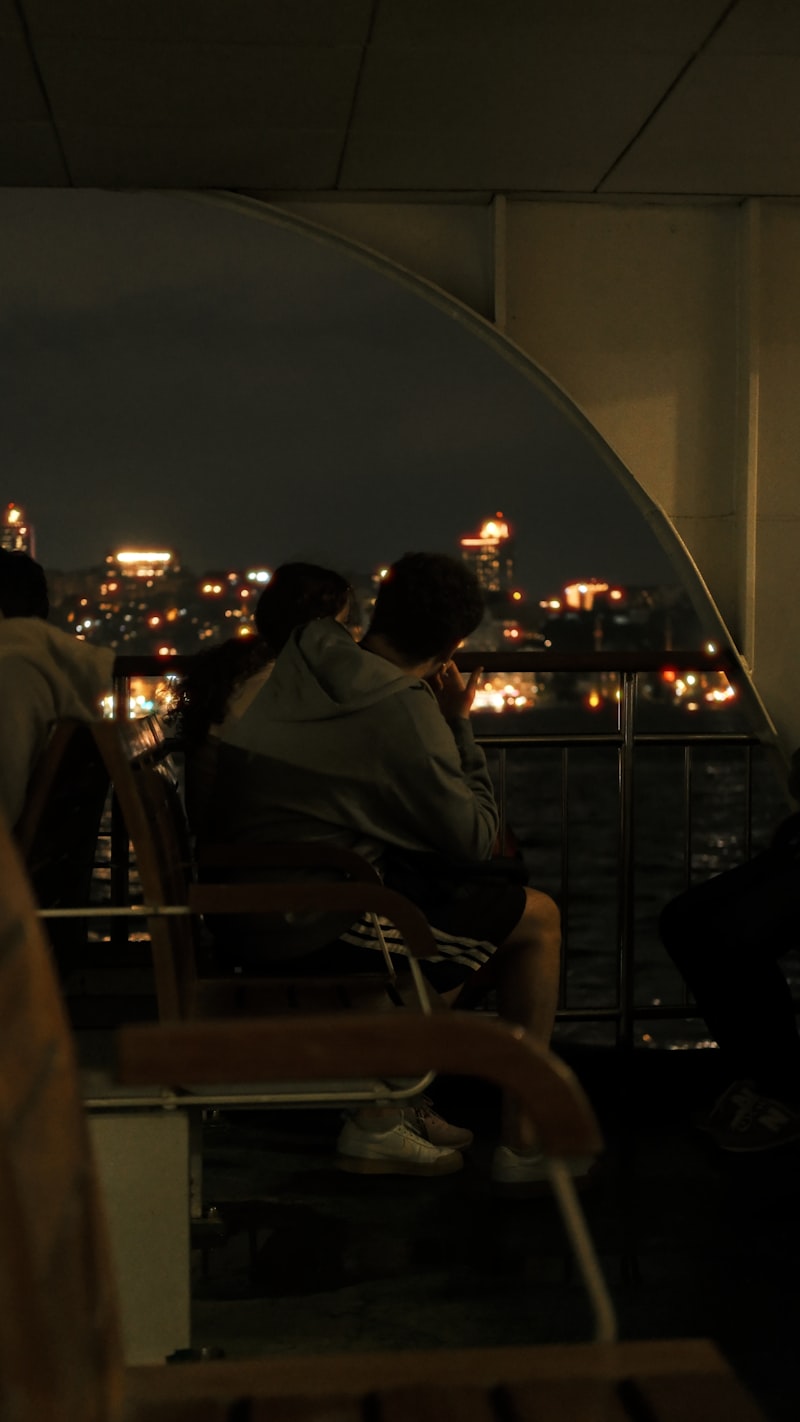 Couple regardant les lumières de la ville depuis un bateau la nuit